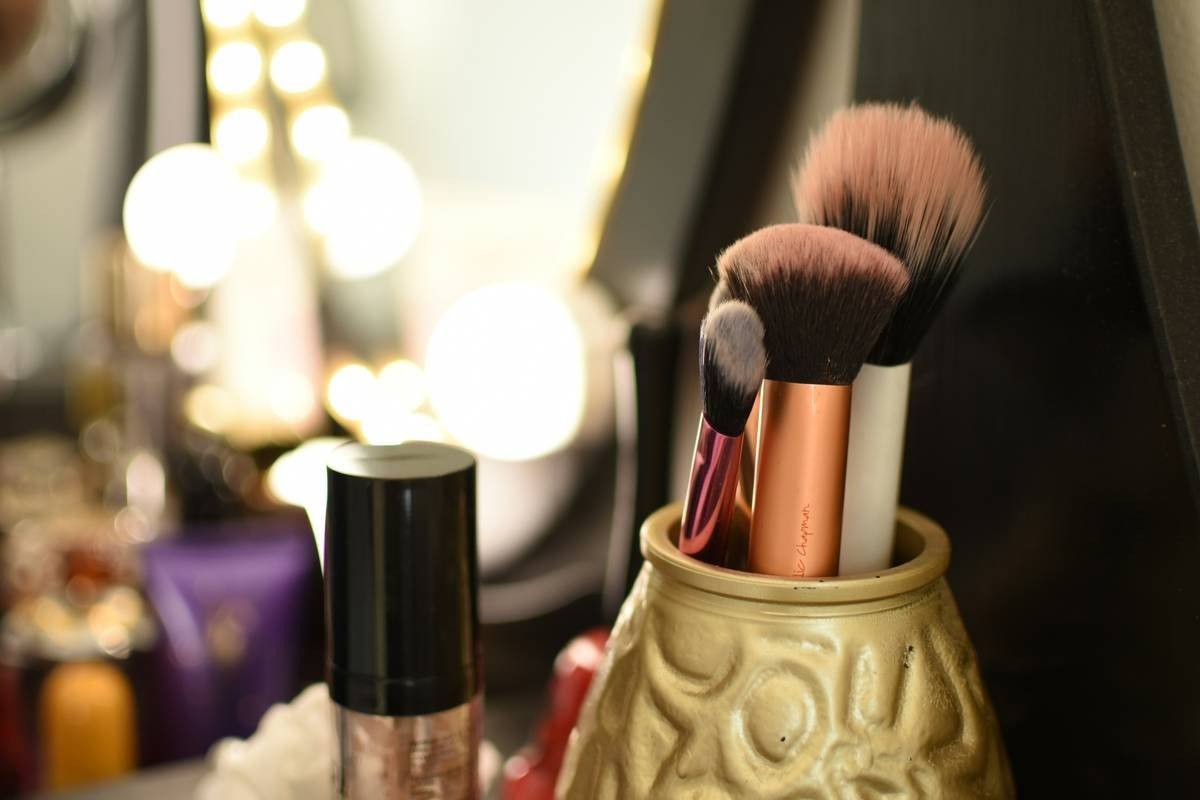 Infographic showing bacteria growth comparison between porous vs non-porous makeup stands, with data from Journal of Cosmetic Science 2023